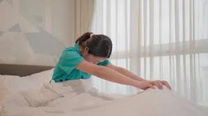 Person doing a gentle stretch on a mat in a sunlit room in the morning